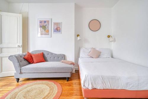 un salon avec un canapé et une chaise dans l'établissement Charming appartment Paris Montmartre, à Paris