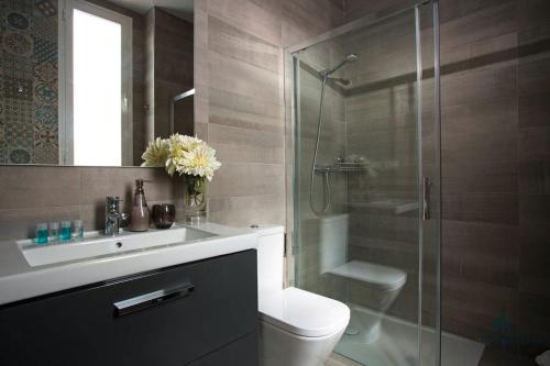 a bathroom with a toilet and a sink and a shower at Living4malaga Guevara Apartment in Málaga