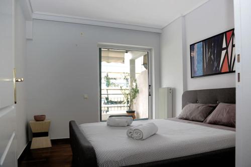Charming apartment near center في أثينا: غرفة نوم عليها سرير وفوط
