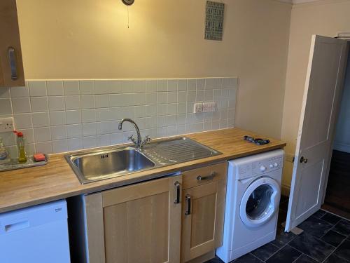 a kitchen with a sink and a washing machine at Captivating Tudor 2 Bedroom Apartment in Ipswich in Ipswich