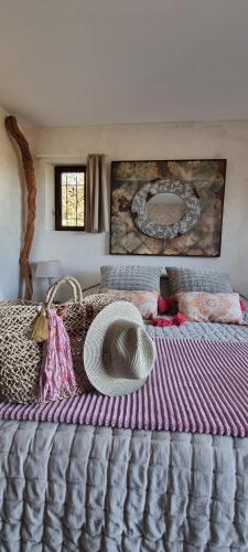 a large bed with a hat on top of it at Le Clos Des Cambres in Les Arcs sur Argens