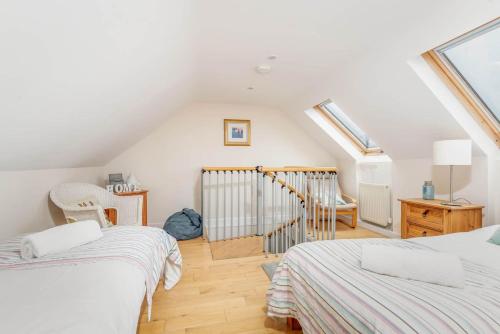 a attic room with two beds and a staircase at Sea View - Stunning views from patio - Sleeps 4 in Pittenweem