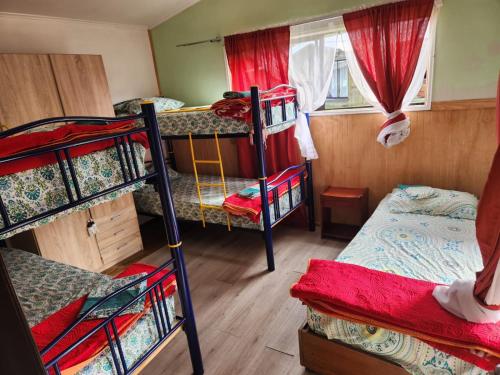 a room with three bunk beds and a window at Cabañas El Ermitaño in Puerto Montt