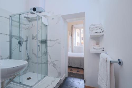 a bathroom with a glass shower and a sink at Prefetti 46 in Rome