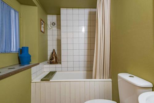 a bathroom with a tub and a toilet and a shower at Folkestone Terrace - quirky vibe holiday home in Kent