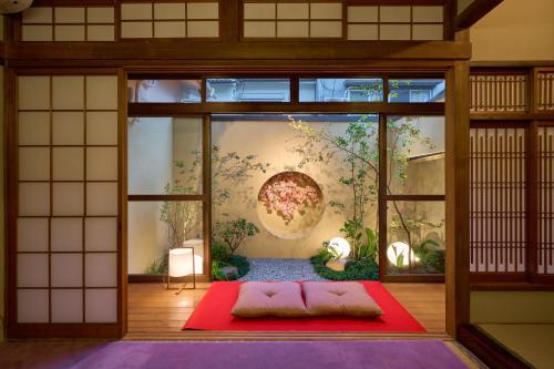 a room with a red rug in front of a wall at Konjaku-So Tengachaya Tea and Relax in Osaka