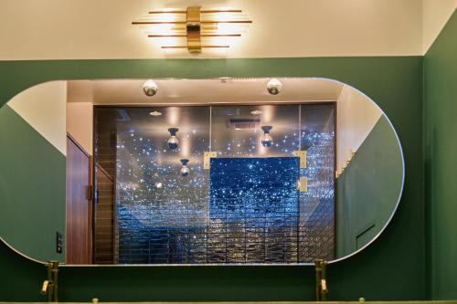 einen Spiegel im Bad mit Spiegelreflexion eines Fensters in der Unterkunft Konjaku-So Tengachaya Tea and Relax in Osaka