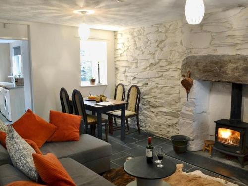 a living room with a couch and a fireplace at Cosy terrace cottage built into the mountain side. in Blaenau-Ffestiniog