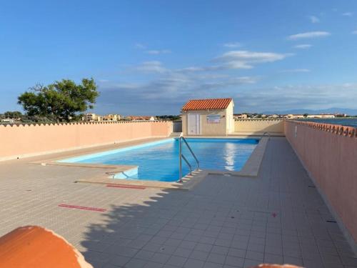 une piscine sur le côté d'un immeuble dans l'établissement Superbe studio rénové avec piscine et vue marina, au Barcarès