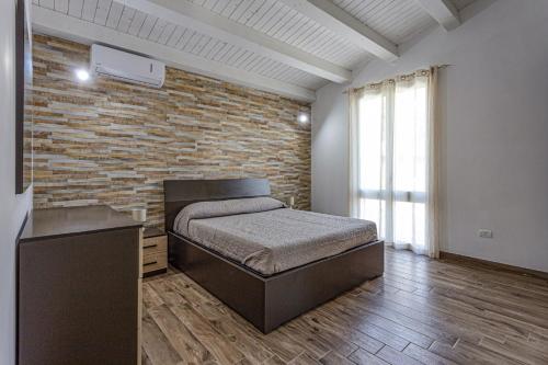 イスピカにあるVilla Pinella by Villa Plusのベッドとレンガの壁がある寝室