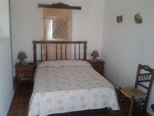 a bedroom with a bed and two chairs and a window at Casa Rural La Noria in La Escucha