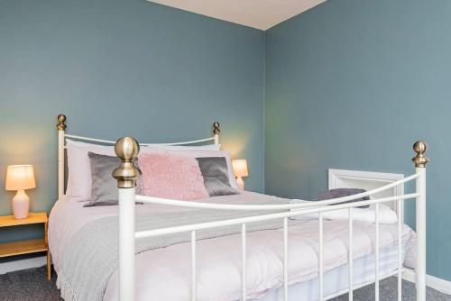 a bedroom with a white bed and blue walls at Ground Floor Apartment with Free WIFI and Parking in Oxford