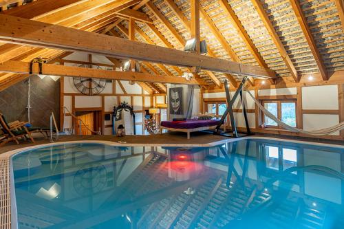 ル・ホーヴァルトにあるLe Chalet du Hohwald- Piscine Intérieure chauffée - Proche Champ du Feuの木製の天井のある家にあるプール