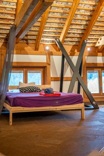 un lit dans une chambre avec un plafond en bois dans l'établissement Le Chalet du Hohwald- Piscine Intérieure chauffée - Proche Champ du Feu, au Hohwald