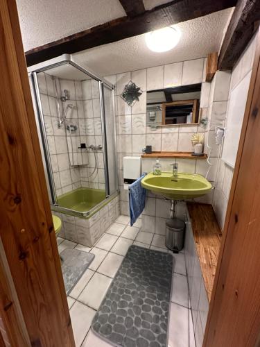 ein Badezimmer mit einem grünen Waschbecken und einer Dusche in der Unterkunft Ferienhaus Historisches Backhäuschen 