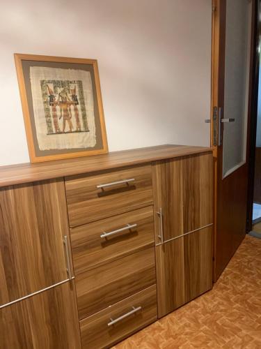 a wooden dresser with a picture on top of it at Lovely room for 2 persons in 3 room flat in Košice