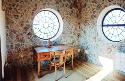 escritorio de madera en una habitación con 2 ventanas en Casa independiente, a tres km de Moratalla, en Moratalla