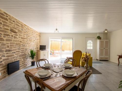 une salle à manger avec une table et un mur de briques dans l'établissement Maison tout confort au cœur du Périgord avec jardin, parking et Wi-Fi - FR-1-616-262, à Fossemagne