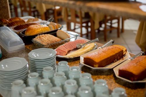 een tafel met borden, gebak en zoete deegwaren bij Pousada Pedra Bonita in Cristal