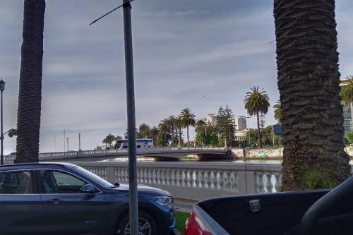 un coche aparcado al lado de una carretera con un puente en Excelente ubicación Apartamento Viña del Mar en Viña del Mar