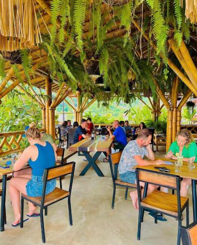 a group of people sitting at tables in a restaurant at La Veranda Hotel & Restaurant in Minca