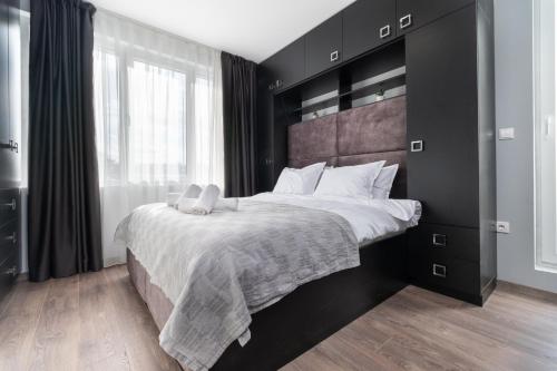 a bedroom with a large bed with a black headboard at Chic 1BR Apartment with Balcony in Plovdiv in Plovdiv