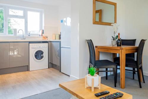 een keuken met een wasmachine en een tafel bij Modern Apt - Comfort Family and Business Travellers with Parking in Oxford