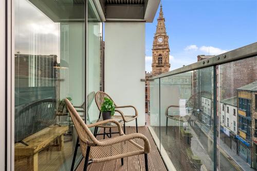 a balcony with two chairs and a clock tower at Host & Stay - The Skandi Hideaway in Liverpool