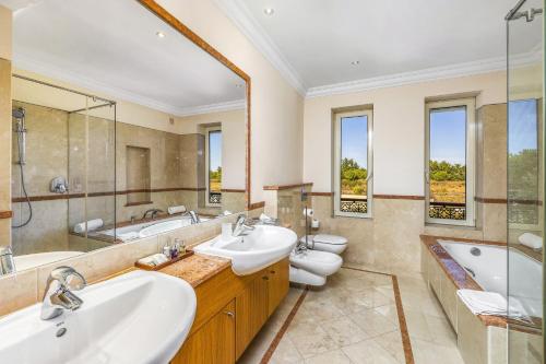 ein Badezimmer mit 2 Waschbecken und 2 WCs in der Unterkunft Villa Monte Rei 43 by Villa Plus in Vila Nova De Cacela