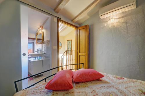 2 almohadas rojas sentadas en una cama en una habitación en Apartment Etta en Fažana