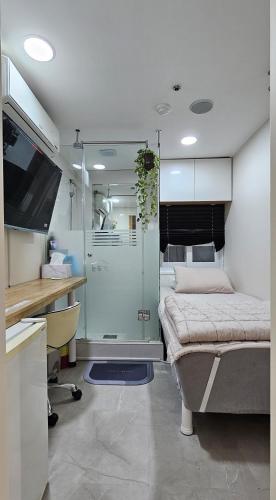 a bedroom with a bed and a desk and a tv at Snowflower Guesthouse in Seoul