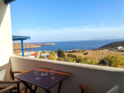 una mesa en un balcón con copas de vino en Maroussa's Apartments, en Rámos