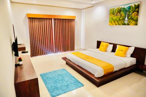 Private 3- bedroom Villa with pool. في كوتا: غرفة نوم بسرير ومخدات صفراء ونافذة