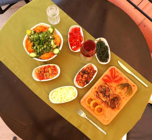 a table topped with plates of food and bowls of vegetables at Kazdaglari Karye Müze Hotel in Kucukkuyu