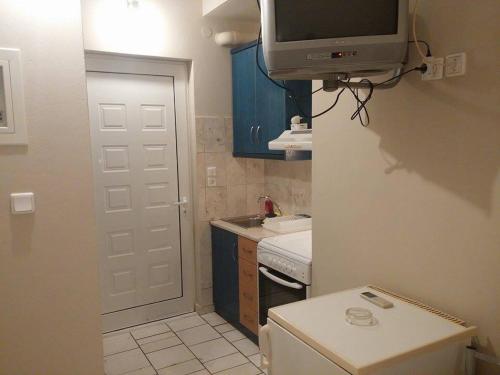 a small kitchen with a tv on the wall at Holiday Tolofona Beach in Eratini