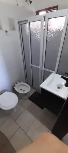 a bathroom with a toilet and a sink at Hotel Sebari in Villa Carlos Paz