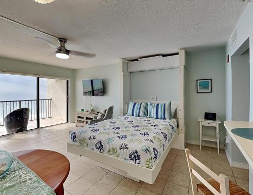 a bedroom with a bed and a desk and a table at Ocean Sands 505 in St. Pete Beach