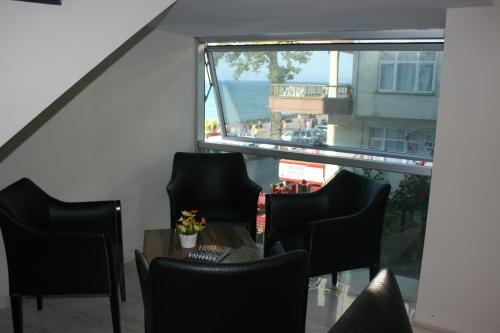 a room with chairs and a table and a large window at Bayraktar Hotel in Akcakoca