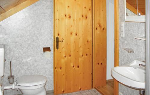 a bathroom with a toilet and a wooden door at Amazing Home In Neukirchen Am Grossven, With 4 Bedrooms And Wifi in Neukirchen am Großvenediger