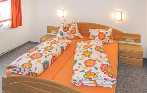クライナルにあるAmazing Apartment In Kleinarl With 3 Bedroomsのオレンジ色のベッド(枕2つ付)