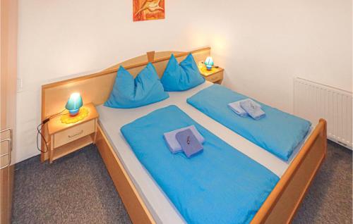 a bedroom with a large bed with blue sheets and blue pillows at Amazing Apartment In Rauris With 1 Bedrooms in Rauris