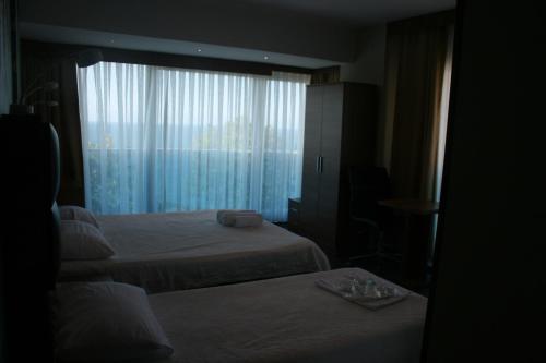 a hotel room with two beds and a window at Bayraktar Hotel in Akcakoca