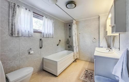 La salle de bains est pourvue d'une baignoire, de toilettes et d'un lavabo. dans l'établissement 5 Bedroom Stunning Home In Torangsvg, à Toranger