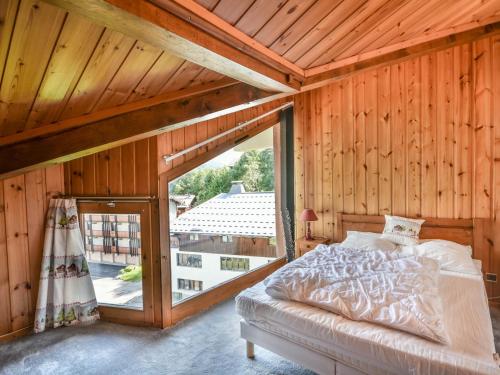 ein Schlafzimmer mit einem Bett und einem großen Fenster in der Unterkunft Appartement Les Gets, 3 pièces, 6 personnes - FR-1-685-35 in Les Gets