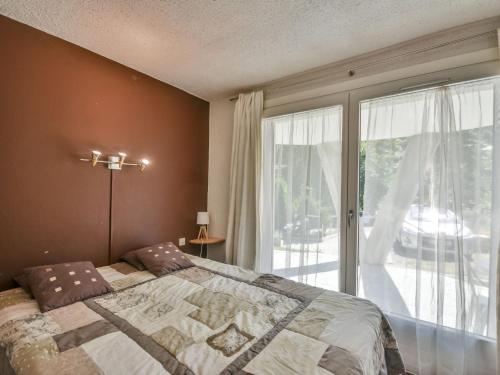 une chambre avec un lit et une grande fenêtre dans l'établissement Appartement cosy aux pieds des pistes avec piscine et tennis, 4 pers, Les Gets - FR-1-685-52, aux Gets