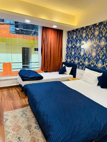 a bedroom with two beds and a window at Hotel shree mahakal krapa in Ujjain