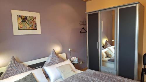 1 dormitorio con cama y espejo en Ferienwohnung Marlene Conrad, en Eppelborn