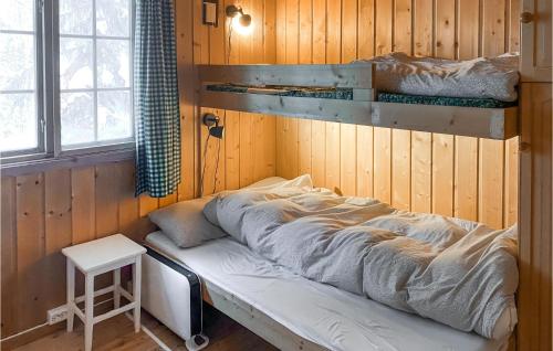 a bed in a room with a wooden wall at Stunning Home In Aurdal With House A Mountain View in Aurdal
