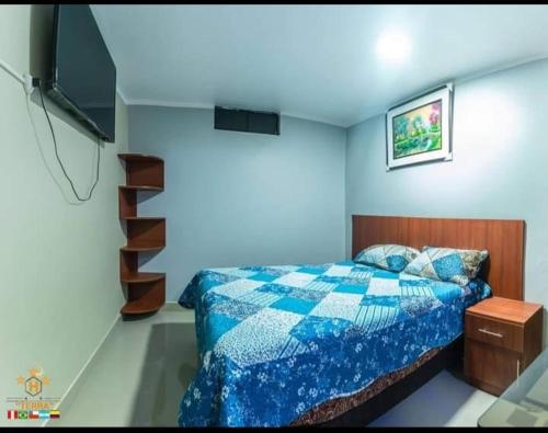 una camera con un letto con una trapunta blu e bianca di HOTEL TERRA ad Ayacucho