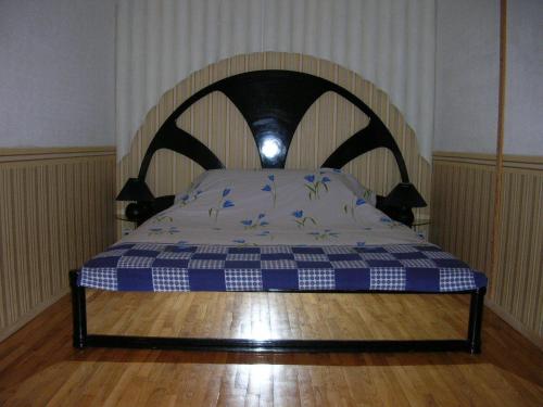 een bed met een blauw en wit geruit matras bij Apartments Arhitektora Artynova in Vinnytsya